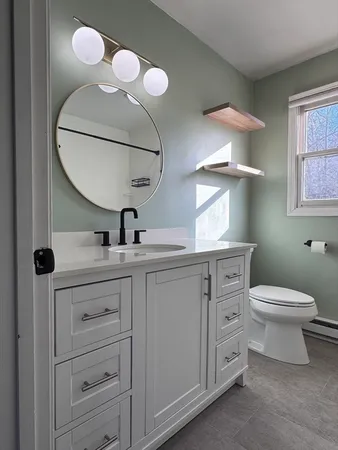 a bathroom with a toilet sink and mirror