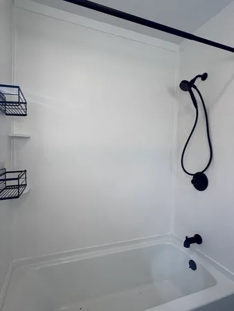 a bathroom with a bath tub with a shower