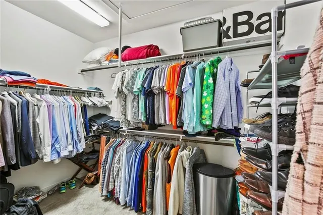 a view of walk in closet with clothes