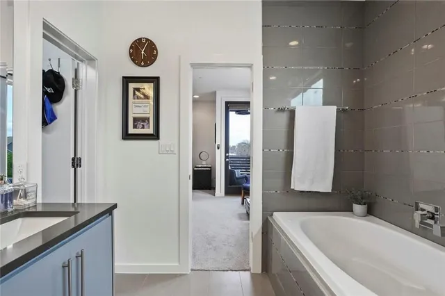 a spacious bathroom with a tub sink and mirror