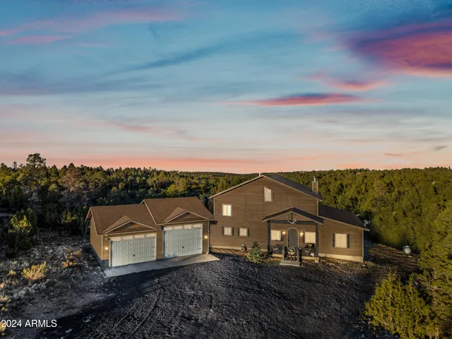 a view of a large house with a big yard and large trees