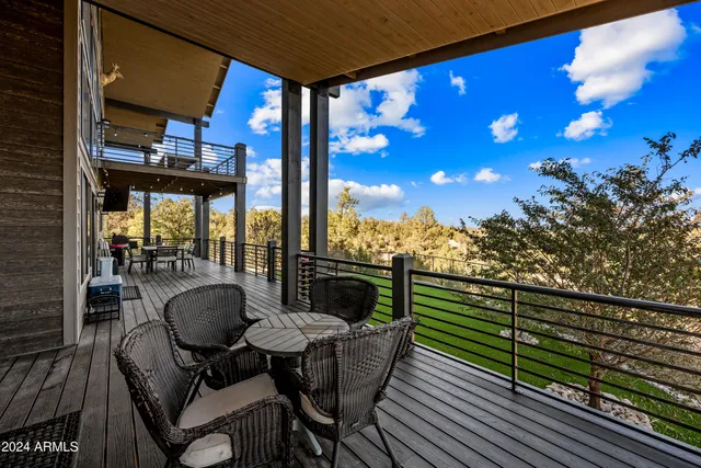 a living room with furniture pool table wooden floor and a ceiling fan