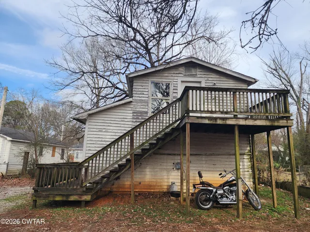 a view of a house with large wooden stairs next to a roof deck
