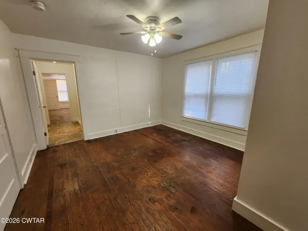 wooden floor in an empty room with a window