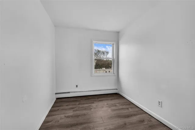 a view of a room with wooden floor and window