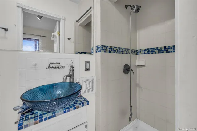 a bathroom with a granite countertop sink a mirror and shower