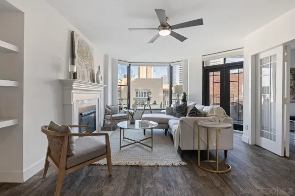 a living room with fireplace furniture and a large window