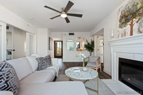 a living room with furniture a fireplace and a ceiling fan