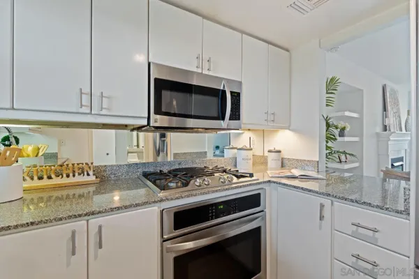 a kitchen with granite countertop stainless steel appliances a stove a sink and a microwave