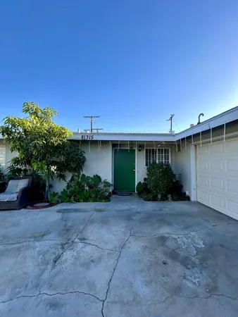 a view of a house with backyard and plants