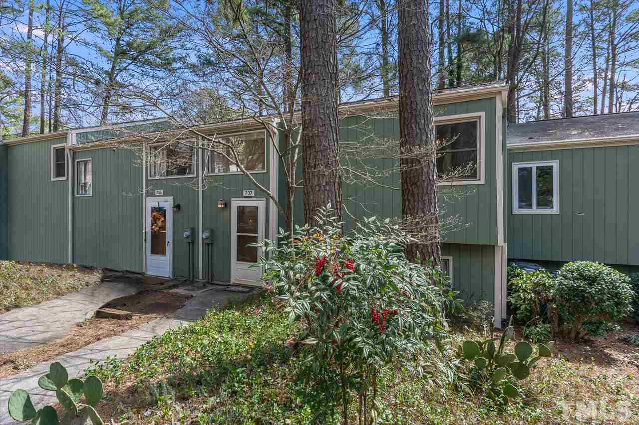 707 Godwin Court Raleigh, NC 27606 - Photo 2 of 26 a view of a brick house with a large windows and flower plants