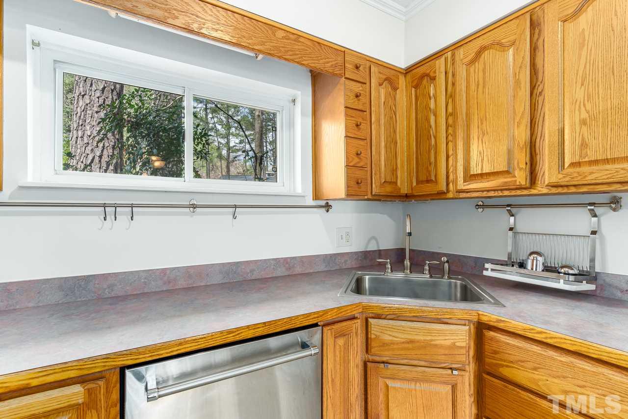 707 Godwin Court Raleigh, NC 27606 - Photo 11 of 26 a kitchen with stainless steel appliances granite countertop white cabinets and a window