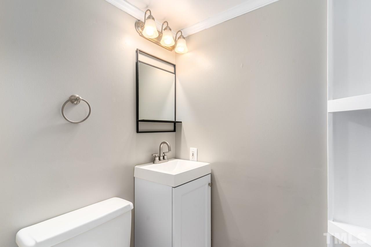 707 Godwin Court Raleigh, NC 27606 - Photo 21 of 26 a bathroom with a toilet sink and mirror