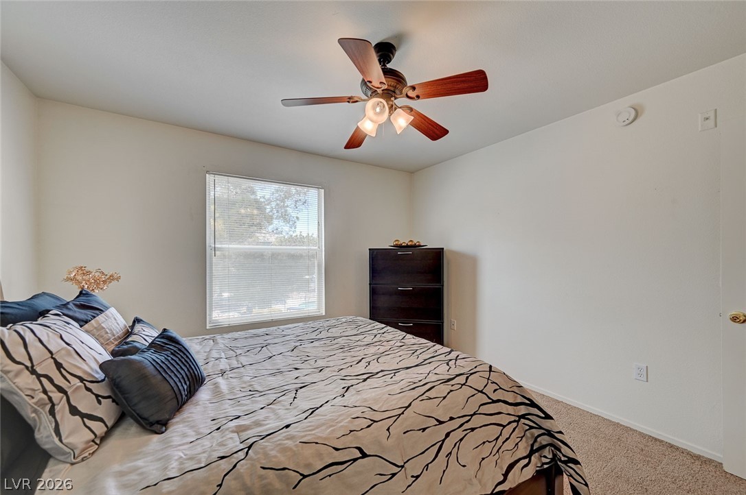 555 East Silverado Ranch Boulevard, Unit 2124 Las Vegas, NV 89183 - Photo 26 of 47 A well-lit bedroom provides comfort and style, with plush carpeting underfoot.