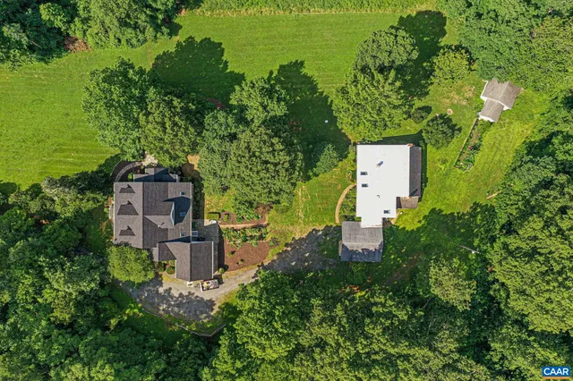 an aerial view of a house with a yard basket ball court and outdoor seating