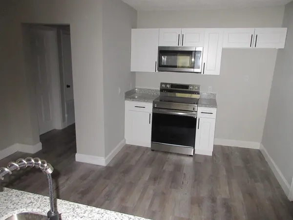 a kitchen with granite countertop a stove and a microwave