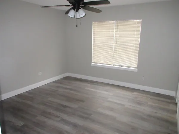 an empty room with a window and a fan