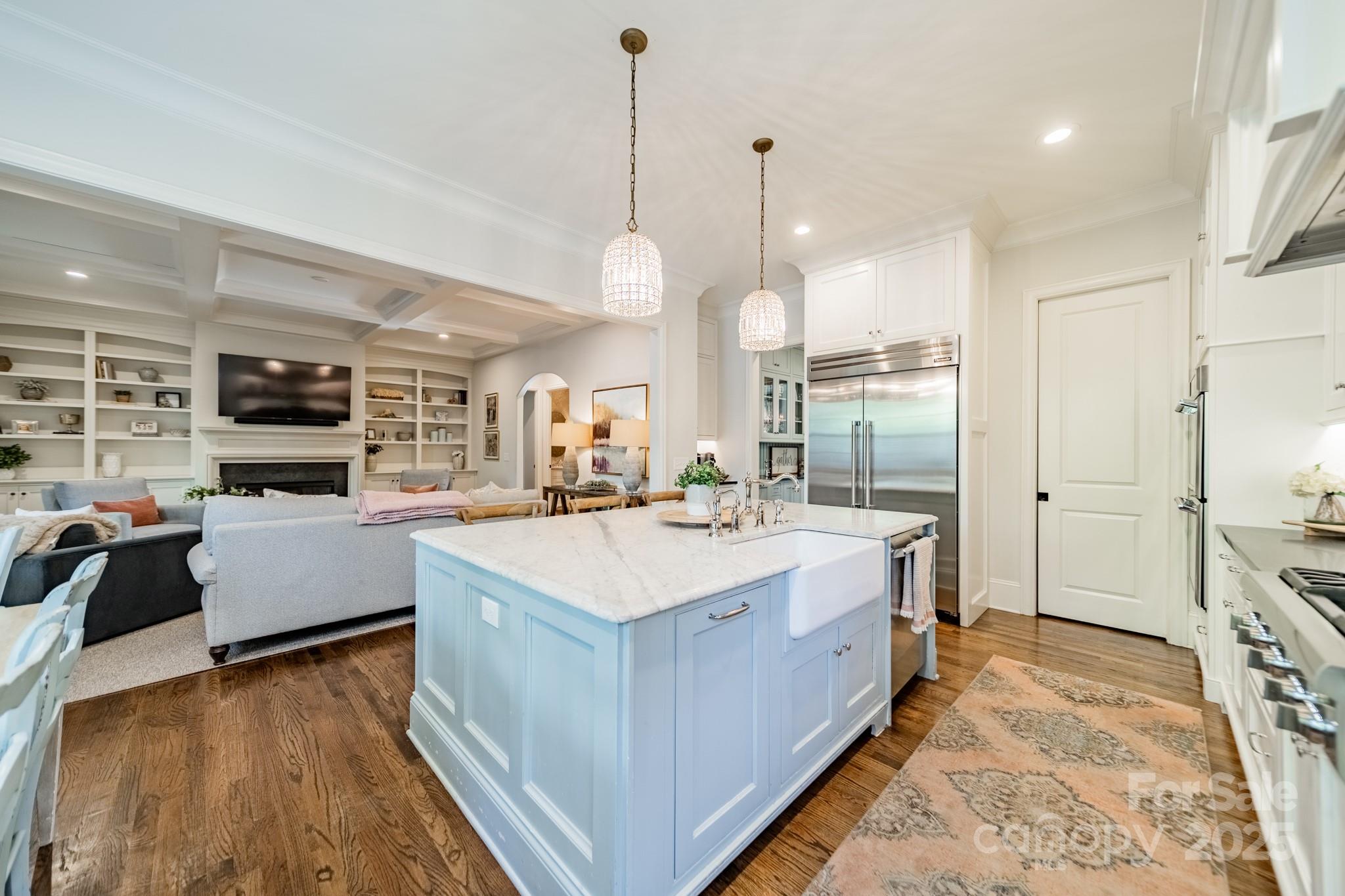 4141 Tyng Way Charlotte, NC 28211 - Photo 12 of 48 a large white kitchen with a large island oven a sink dishwasher and a fireplace with wooden floor