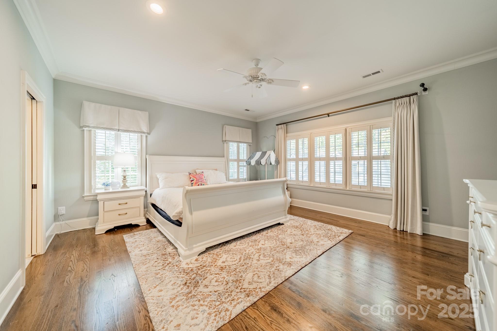 4141 Tyng Way Charlotte, NC 28211 - Photo 24 of 48 a spacious bedroom with a large bed and a wooden floor