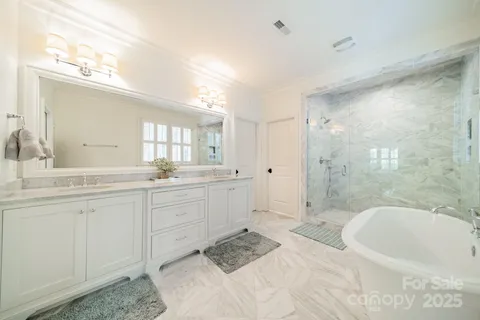 a bathroom with a granite countertop sink a toilet a mirror and bathtub