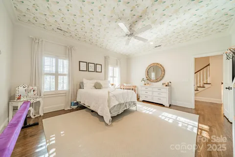 a spacious bedroom with a bed a dresser and next to a window