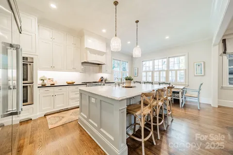 a large kitchen with kitchen island a large island in the center and stainless steel appliances