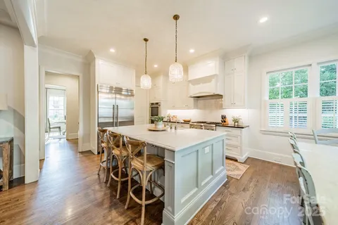 a large kitchen with kitchen island a large island in it