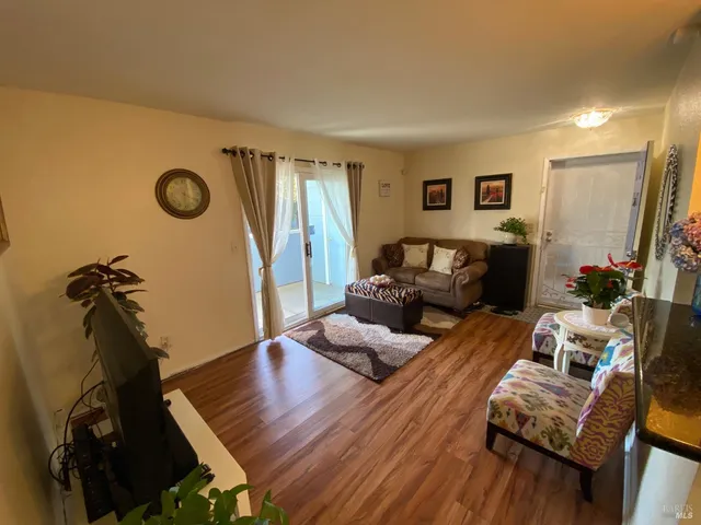 a room with stainless steel appliances kitchen island granite countertop a table chairs and a refrigerator