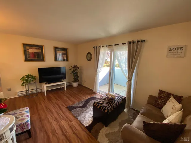 a kitchen with stainless steel appliances granite countertop a refrigerator a stove a sink dishwasher a dining table and chairs with wooden floor