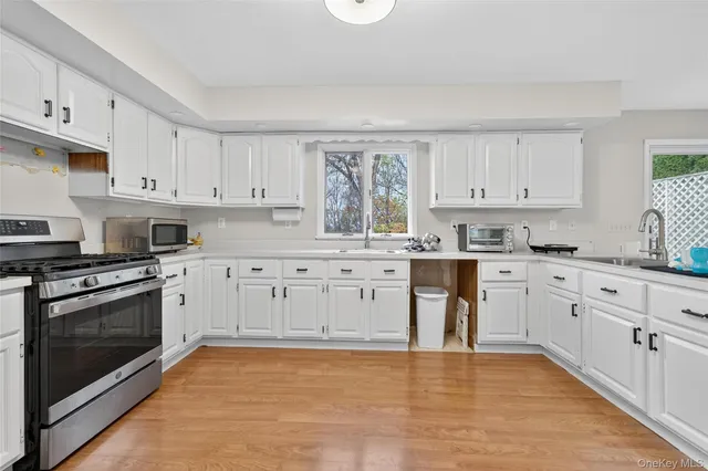 a kitchen with granite countertop a stove top oven sink and cabinets
