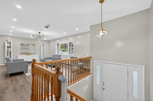 a view of front door and bedroom with furniture wooden floor and window