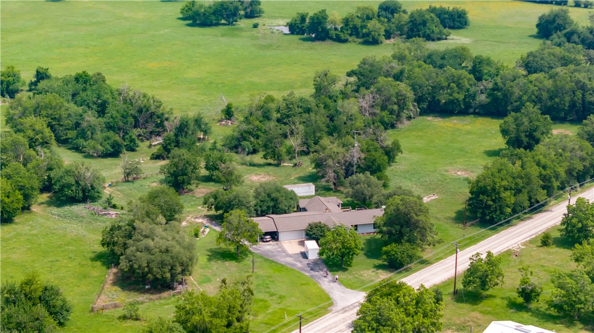 an aerial view of residential houses with outdoor space and trees all around