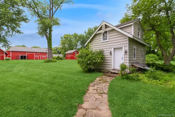 a front view of a house with a yard and trees