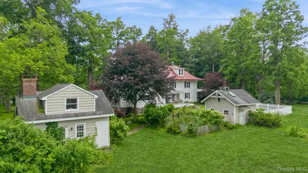 an aerial view of residential house with an outdoor space and trees all around