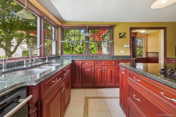 a large kitchen with granite countertop a sink and a counter top space