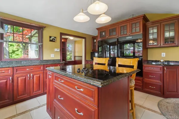 a dining room with granite countertop wooden floor and large windows