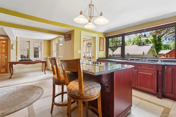 a kitchen with stainless steel appliances granite countertop wooden cabinets a stove and a large window