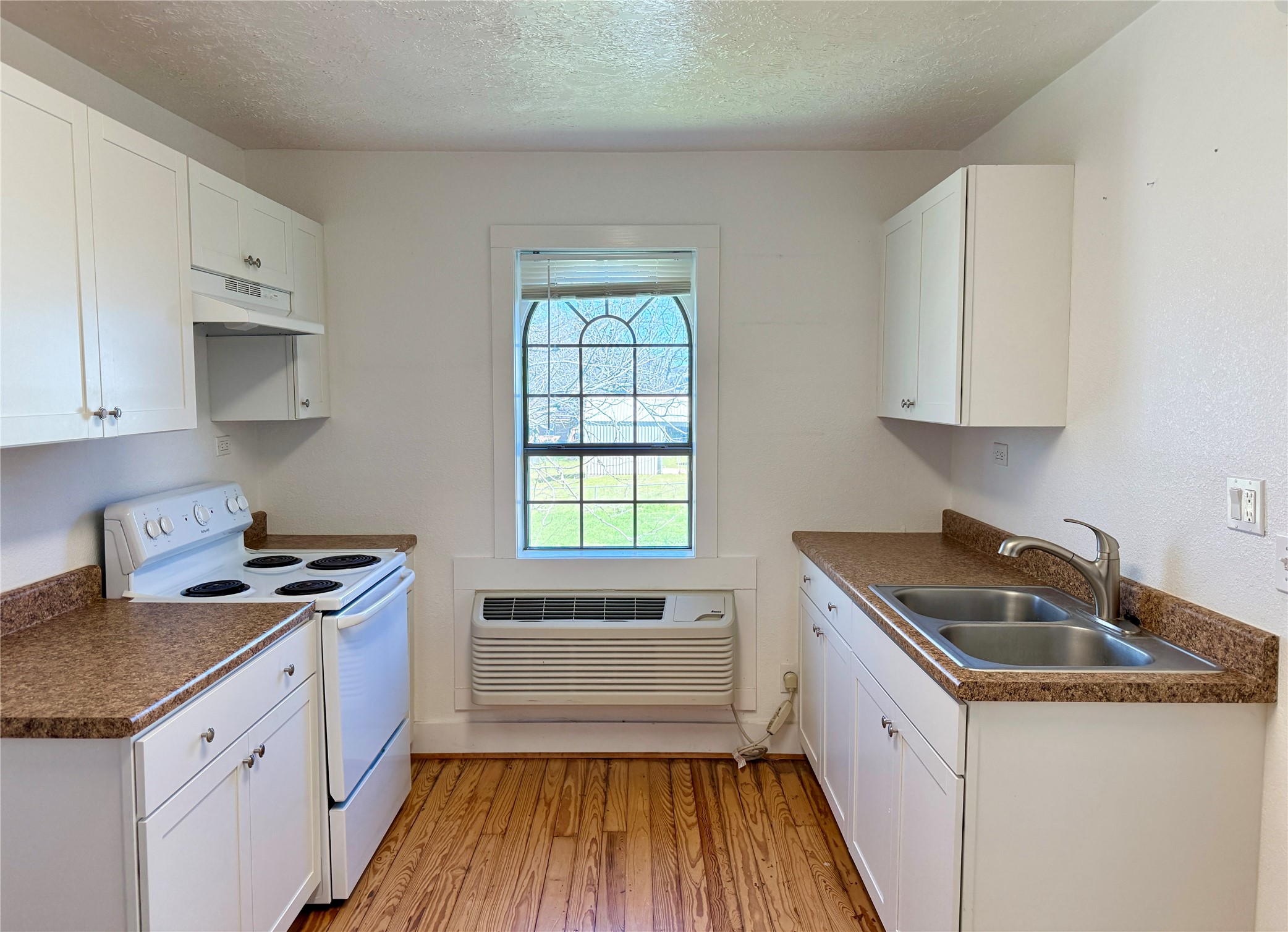 232 South Tesch Street, Unit 236 Bellville, TX 77418 - Photo 2 of 8 a kitchen with granite countertop a sink a stove and cabinets