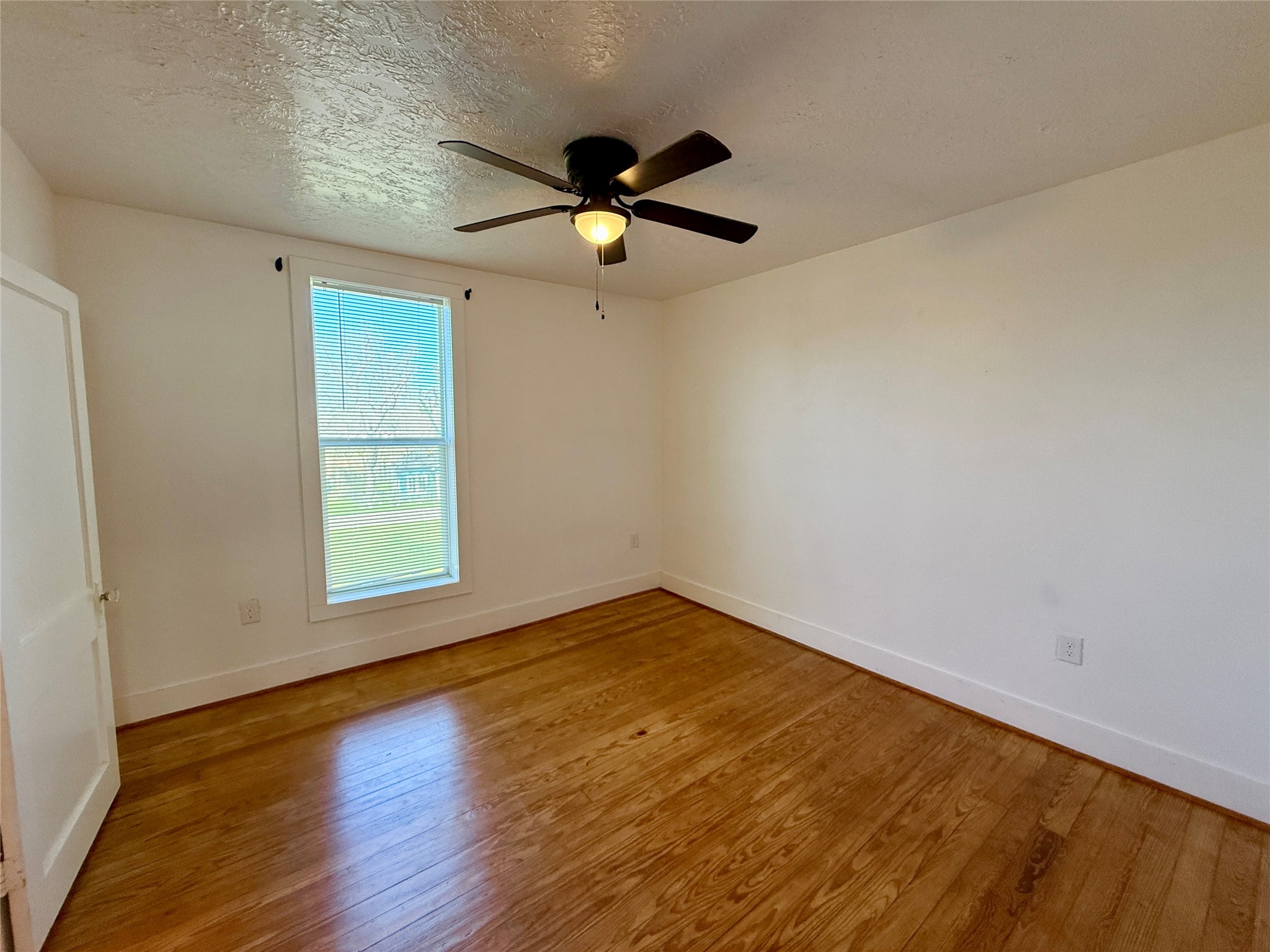 232 South Tesch Street, Unit 236 Bellville, TX 77418 - Photo 5 of 8 an empty room with wooden floor fan and windows