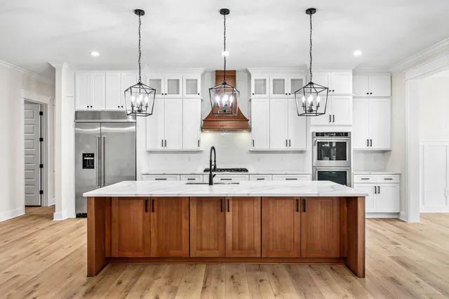 a kitchen with stainless steel appliances a sink a stove and a wooden floors