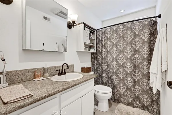 a bathroom with a granite countertop sink toilet and shower