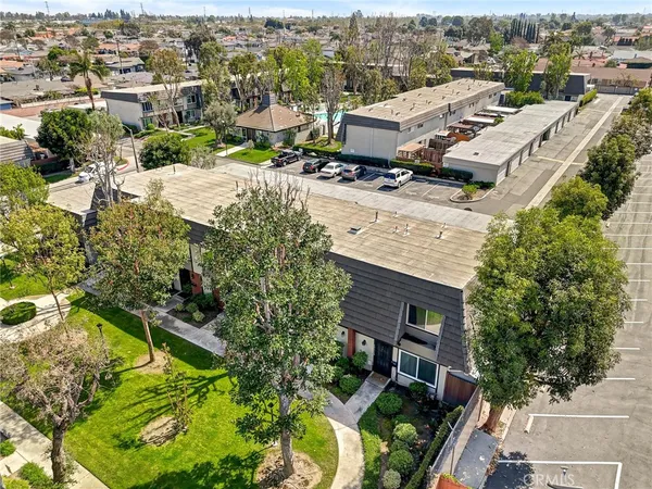 a view of a house with a big yard plants and large trees