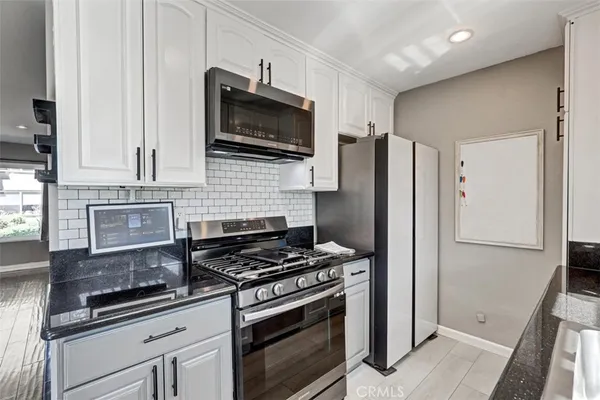 a kitchen with stainless steel appliances a stove microwave and refrigerator