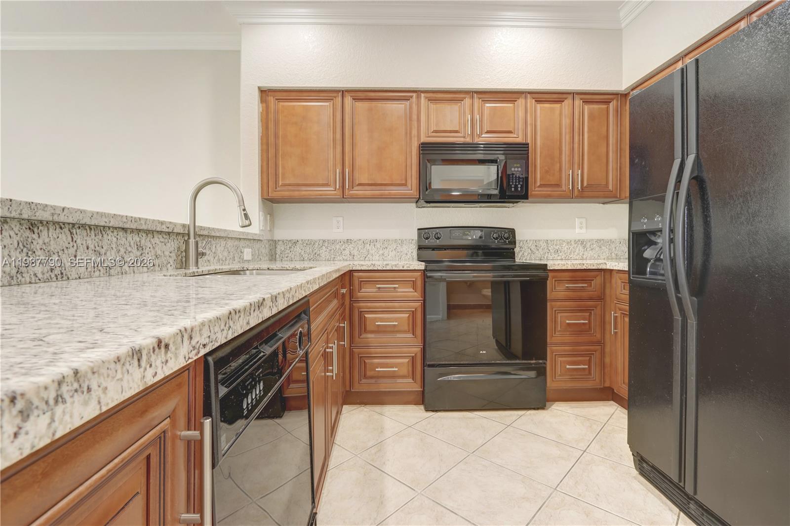 2830 Southwest 83rd Terrace, Unit 101 Miramar, FL 33025 - Photo 11 of 21 a kitchen with stainless steel appliances granite countertop a stove top oven a sink and dishwasher