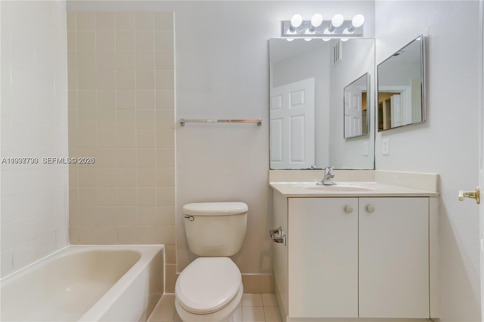 2830 Southwest 83rd Terrace, Unit 101 Miramar, FL 33025 - Photo 14 of 15 a bathroom with a toilet a sink a mirror a bathtub and vanity