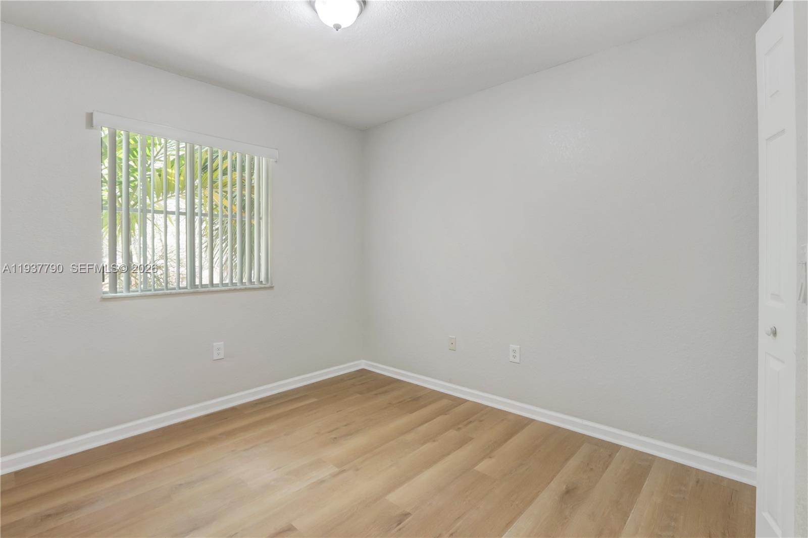 2830 Southwest 83rd Terrace, Unit 101 Miramar, FL 33025 - Photo 17 of 21 wooden floor in an empty room with a window