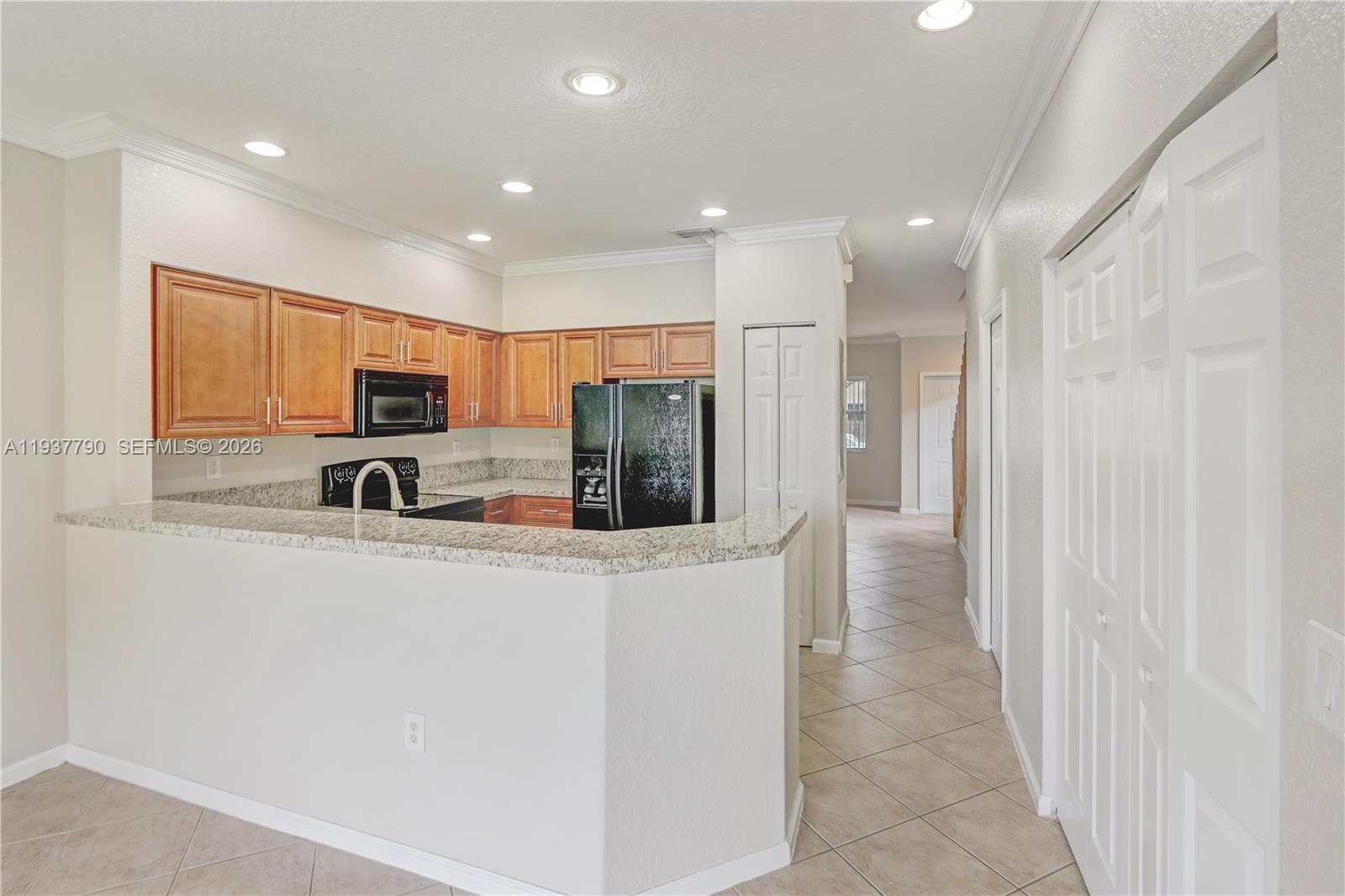 2830 Southwest 83rd Terrace, Unit 101 Miramar, FL 33025 - Photo 7 of 21 a kitchen with stainless steel appliances granite countertop a refrigerator and a stove top oven