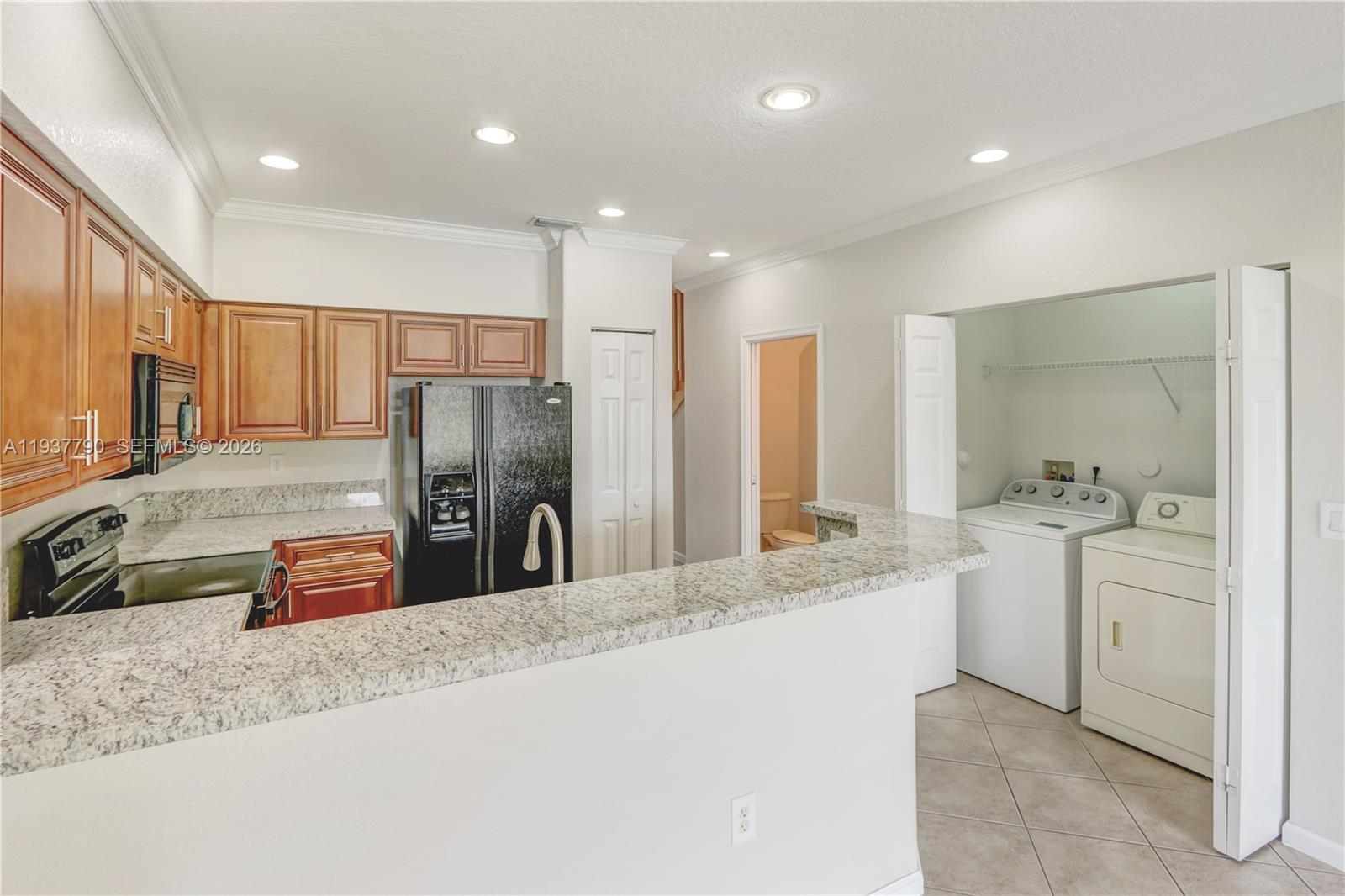 2830 Southwest 83rd Terrace, Unit 101 Miramar, FL 33025 - Photo 8 of 21 a kitchen with stainless steel appliances granite countertop a sink stove and refrigerator