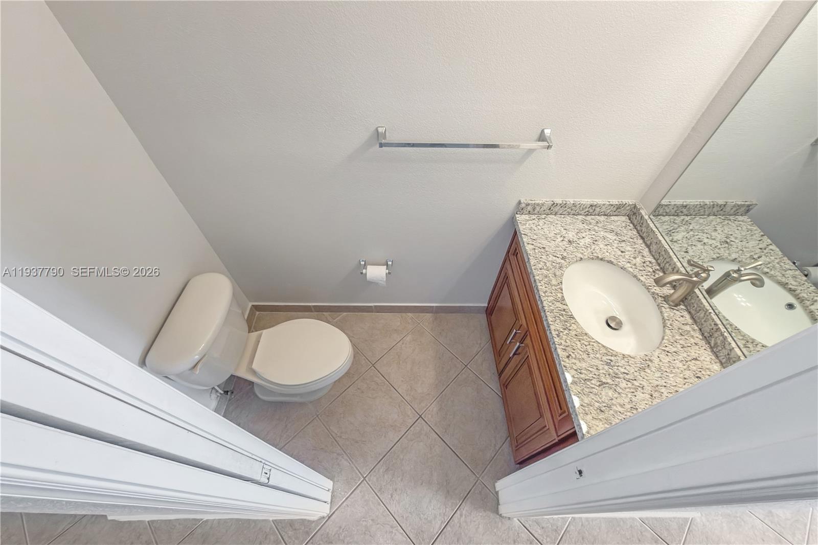 2830 Southwest 83rd Terrace, Unit 101 Miramar, FL 33025 - Photo 10 of 21 a bathroom with a toilet sink vanity granite and mirror