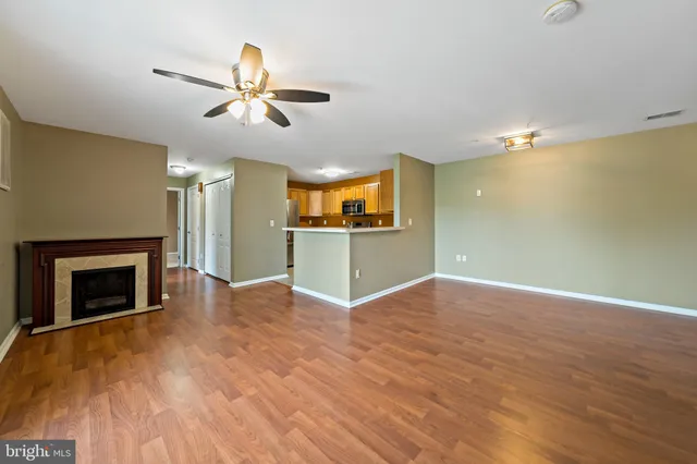 a view of a livingroom with a fireplace and a ceiling fan